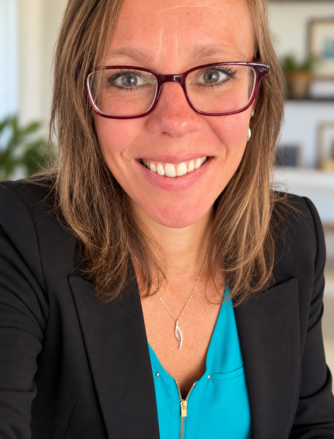 Jessica smiling in a turquoise blouse and dark blazer